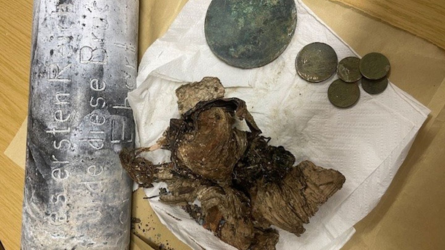 Silber- und Kupfermünzen, ein Zeitungsartikel und Fotos wurden seit dem beim Bau einer Brücke in Hof im Jahr 1928 in einer Zeitk