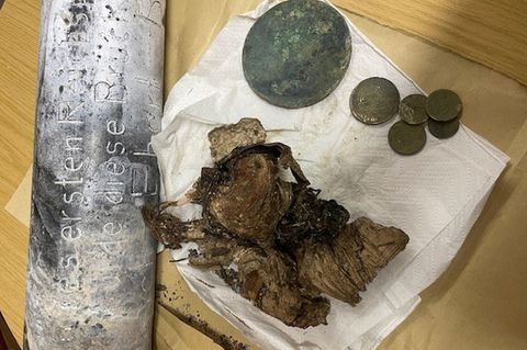 Silber- und Kupfermünzen, ein Zeitungsartikel und Fotos wurden seit dem beim Bau einer Brücke in Hof im Jahr 1928 in einer Zeitk