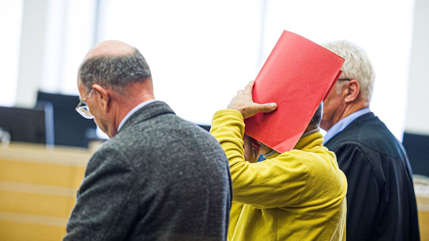 Zum Prozessauftakt verdeckte der Angeklagte sein Gesicht mit einem Ordner. Foto: Moritz Frankenberg/dpa