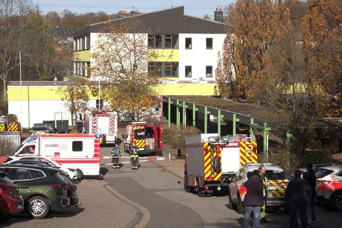 Feuerwehr und Krankenwagen stehen vor einer Schule, in der 32 Menschen mutmaßlich durch Reizgas verletzt wurden. Sie wurden von