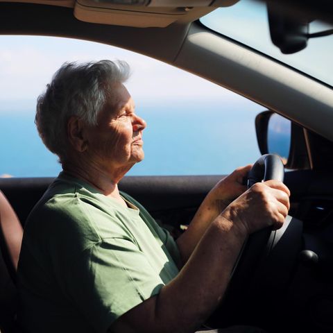 Eine ältere Frau fährt Auto