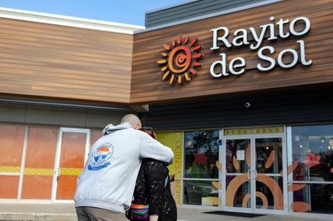 Zwei Eltern umarmen sich vor der Kita in Chicago, in der Agenten der US-Einwanderungsbehörde ICE eine Erzieherin festnahmen