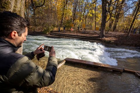 Freizeitsurfer Alexander Neumann fotografiert die - zurzeit nicht funktionstüchtige - Eisbachwelle im Englischen Garten. Foto: P