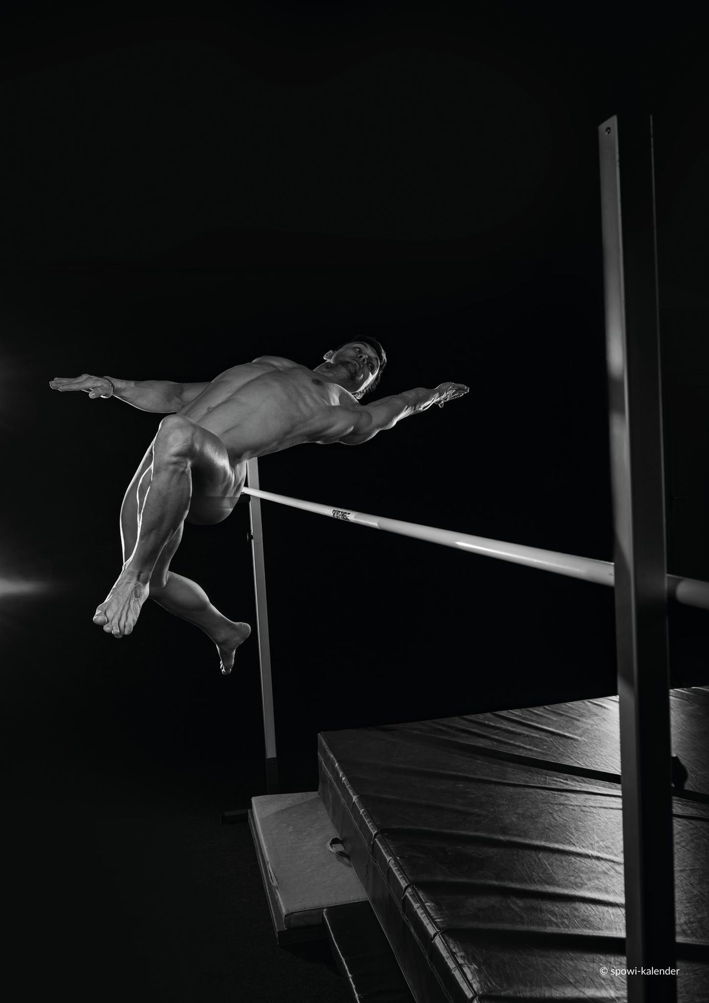 Ein nackter Mann springt über einen Latte