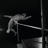 Ein nackter Mann springt über einen Latte