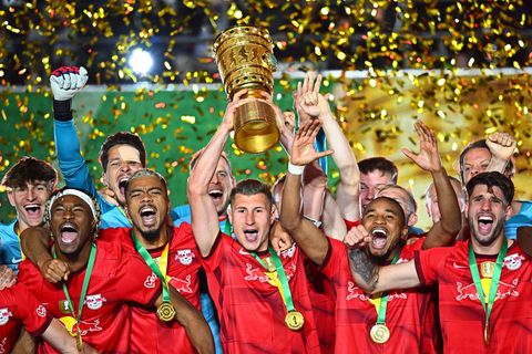 Leipzigs Willi Orban hält die Siegertrophäe in die Höhe und bejubelt mit seinen Teamgefährten den zweiten Pokalsieg in der Verei