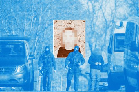 Polizeibeamte laufen bei einer Hausdurchsuchung in Reimershagen über die Straße