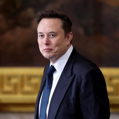 Elon Musk in einem Anzug schaut leicht lächelnd an dem Betrachter vorbei