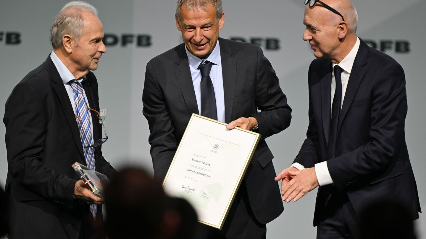 Bernard Dietz (l) wird von Jürgen Klinsmann und DFB-Präsident Bernd Neuendorf für die Ernennung zum Ehrenspielführer gratuliert.