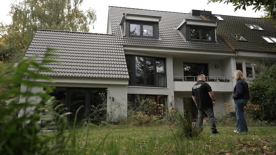 Experte und Reporterin stehen vor ihrem Haus