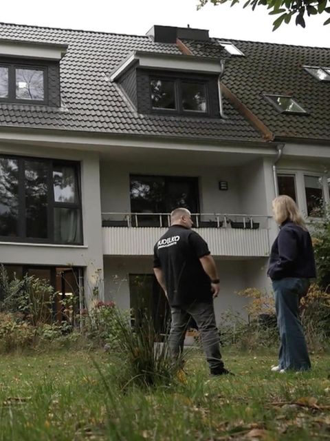 Experte und Reporterin stehen vor ihrem Haus