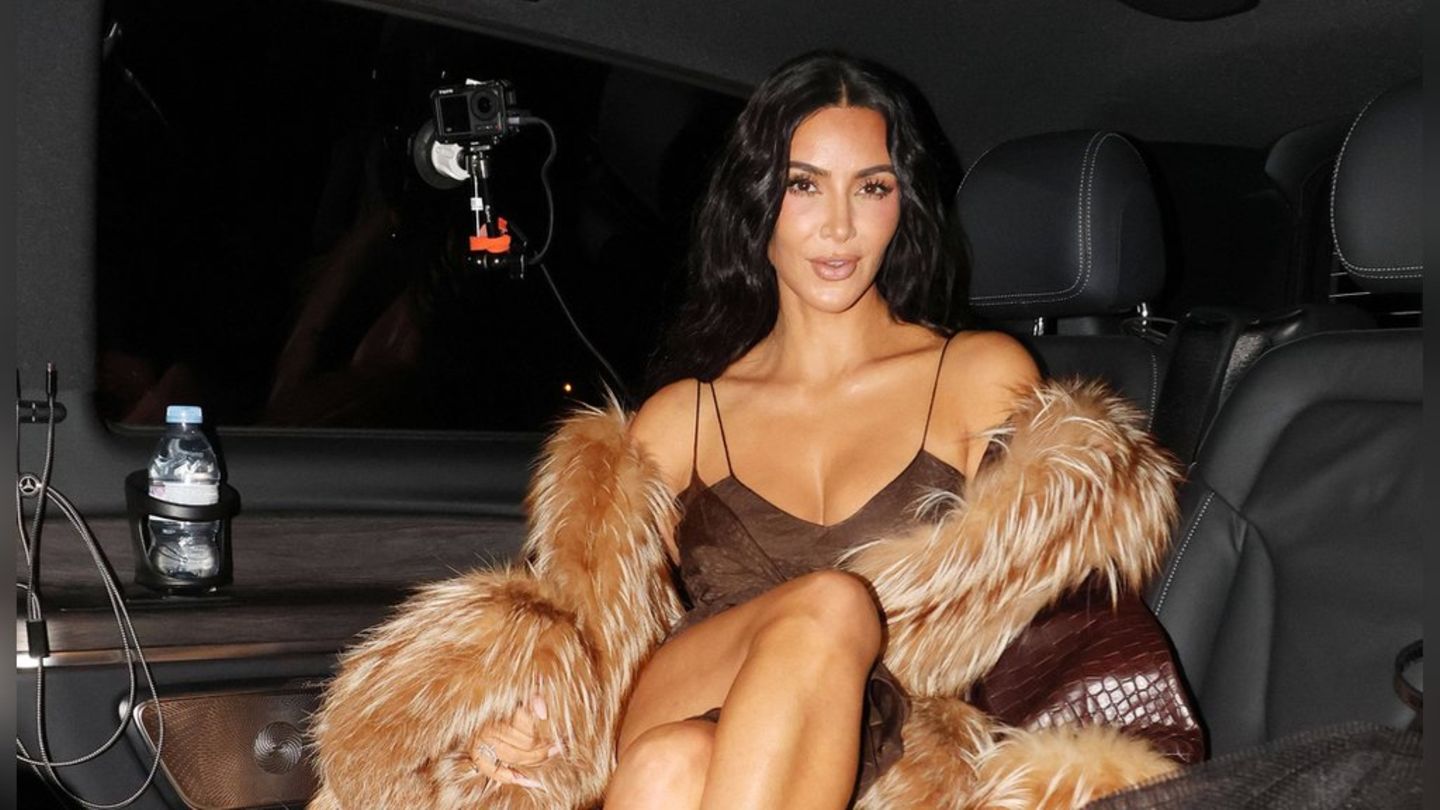 Kim Kardashian räkelt sich mit Kleid und Pelzmantel im Auto