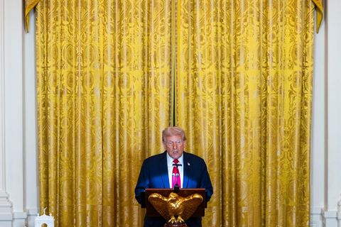 Donald Trump hält vor einem Goldvorhang im im East Room des Weißen Hauses eine Rede