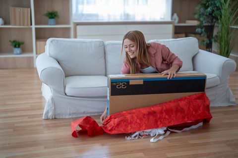 Black Friday Fernseher: Eine Frau packt ihren neuen TV aus