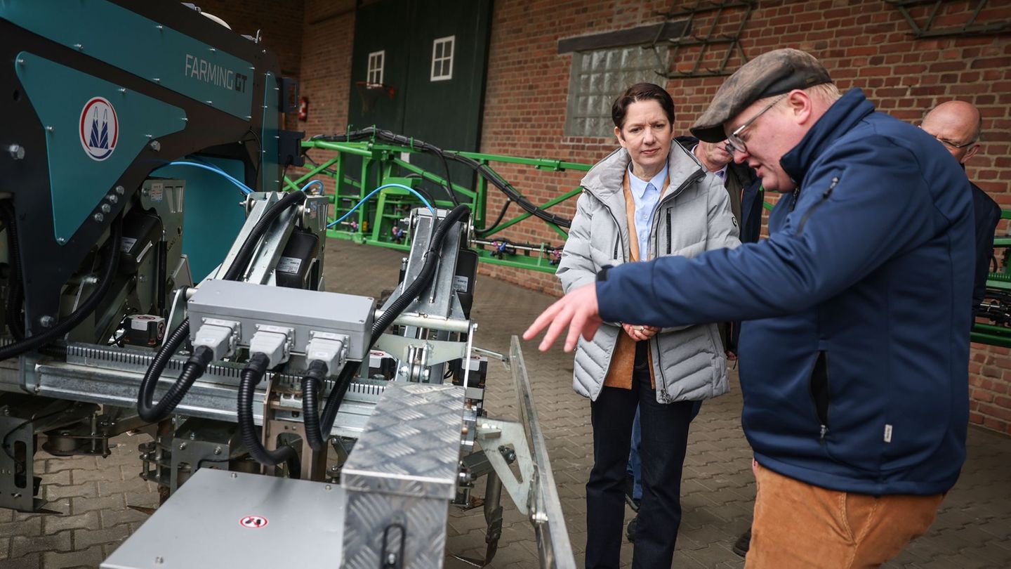 NRW-Agrarministerin Silke Gorißen lässt sich einen neuen, sogenannten Hackroboter erklären. Foto: Oliver Berg/dpa