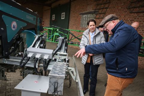 NRW-Agrarministerin Silke Gorißen lässt sich einen neuen, sogenannten Hackroboter erklären. Foto: Oliver Berg/dpa