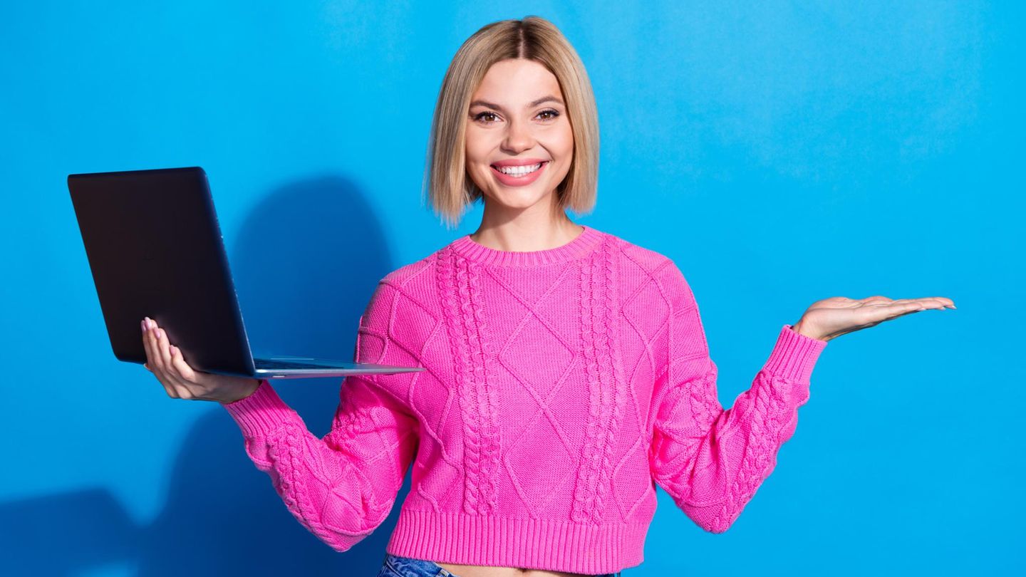 Black Friday Laptop: Eine Frau lächelt und hält dabe ihren Laptop in der Hand