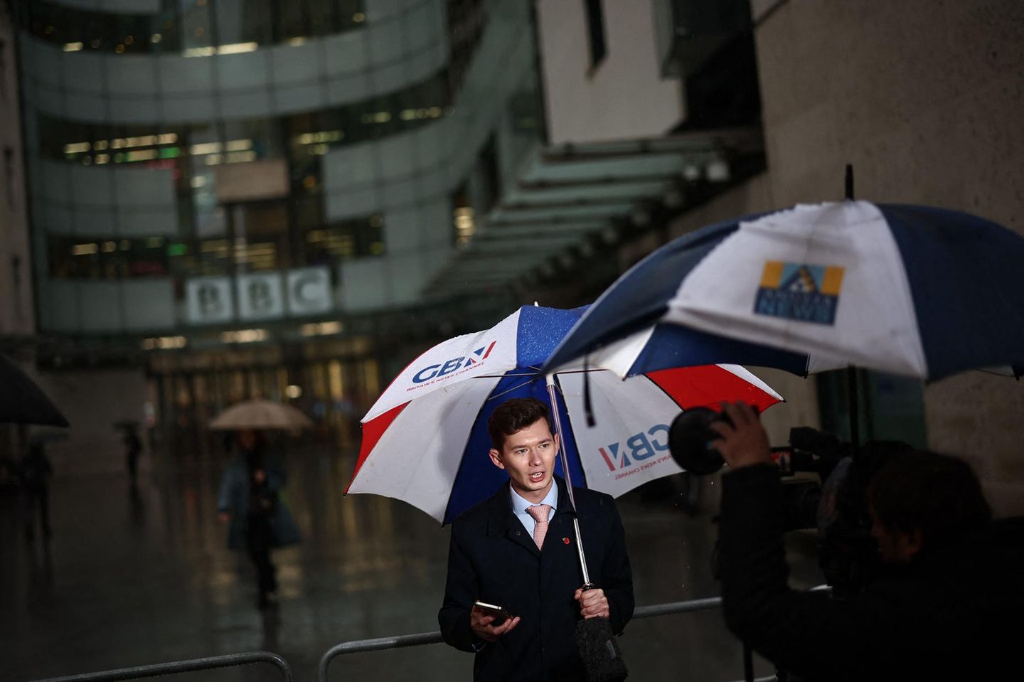 Die BBC und ihre Widersacher: Vor dem Hauptgebäude des Senders in London berichtet ein Reporter des rechten Privatsenders GB News über die Krise des Medienhauses