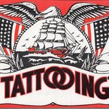 Schild mit der Aufschrift "Tattooing" und US-Flaggen