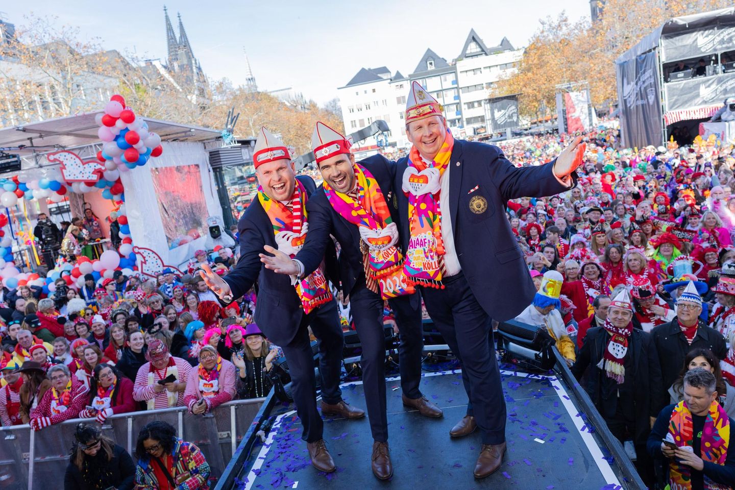In der Kölner Altstadt schunkelten die Jecken bei strahlendem Sonnenschein mit dem designierten Dreigestirn aus Prinz Niklas I. (M, Niklas Jüngling), Bauer Clemens (r, Clemens von Blanckart) und Jungfrau Aenne (Stefan Blatt) 