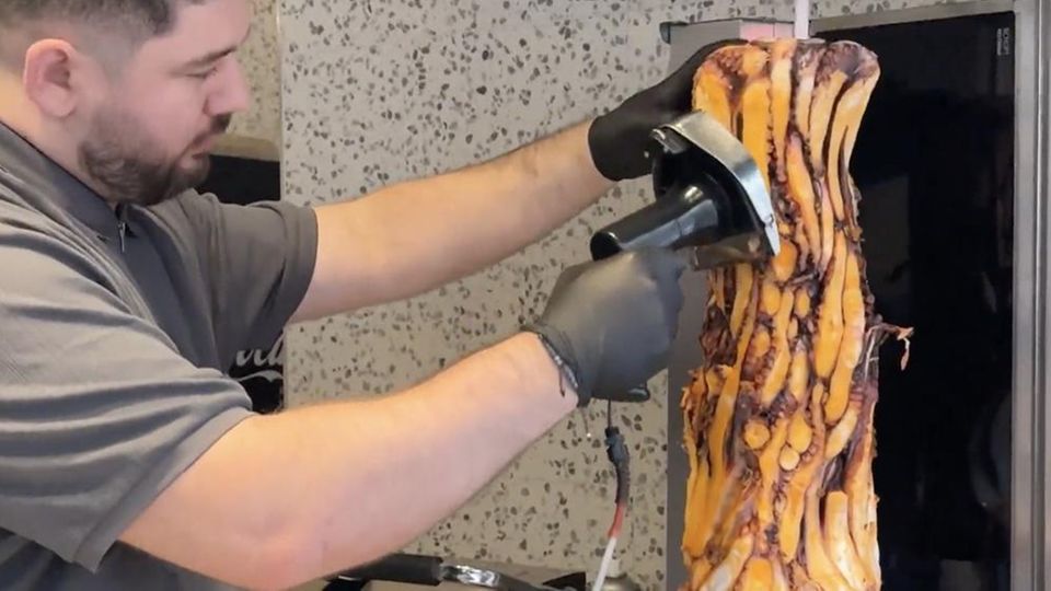 Ein Mitarbeiter des Imbiss schneidet Tentakeln für den nächsten Oktopus-Döner ab.