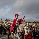 Prag, Tschechien. Ein als der heilige Martin von Tours verkleideter Mann reitet während einer Prozession auf der mittelalterlichen Karlsbrücke auf einem weißen Pferd. Die Ankunft des heiligen Martins auf einem weißen Pferd ist ein Volksbrauch, der mit dem Martinstag verbunden ist. Der Legende nach kündigt er den Winter und den ersten Schneefall an. In tschechischen Städten und Dörfern wird dieser Tag mit Laternenumzügen, Kostümaufführungen und dem Genuss von jungem Wein und Gänsebraten gefeiert, die den Überfluss und das Ende des landwirtschaftlichen Jahres symbolisieren