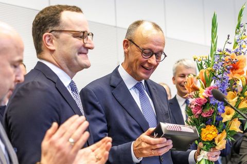 Jens Spahn (l.) überreicht Friedrich Merz zu seinem 70. Geburtstag neue Krawatten.