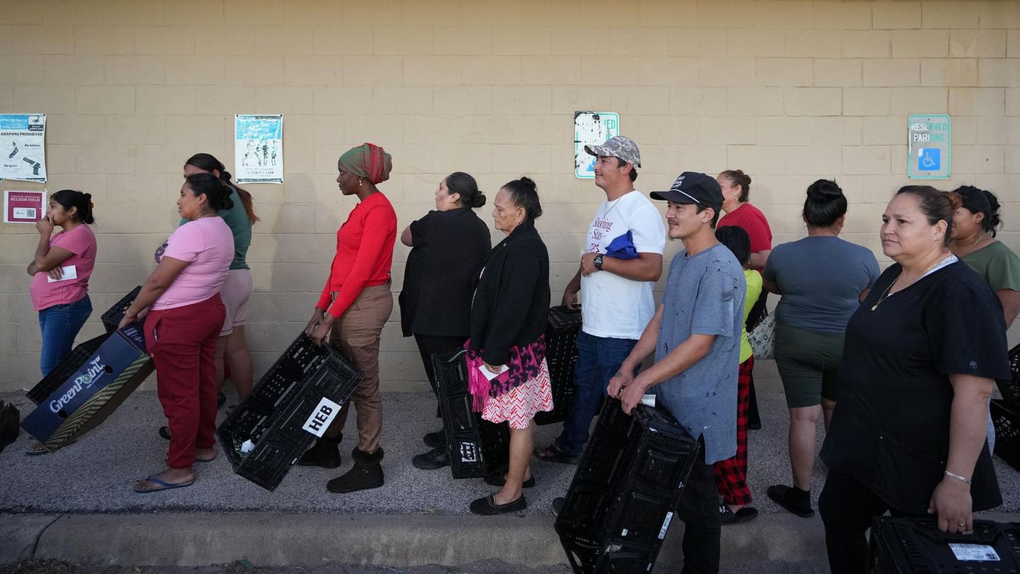 Menschen mit Taschen stehen vor der Central Texas Food Bank in den USA an, weil SNAP ausgesetzt ist