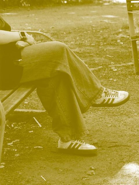 Sophie sitzt auf einer Bank, man sieht nur ihre Beine