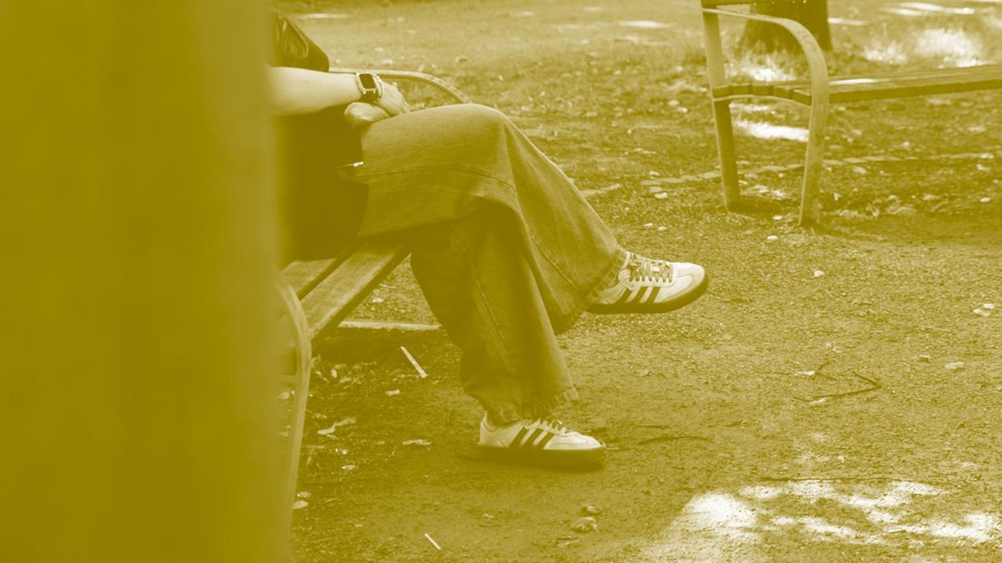 Sophie sitzt auf einer Bank, man sieht nur ihre Beine