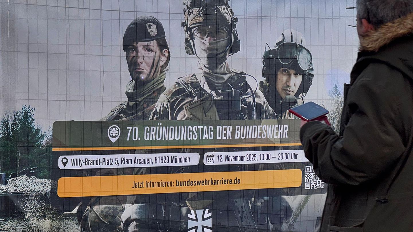Wehrdienstleistende der Bundeswehr auf einem Banner zum 70-jährigen Bestehen der Truppe