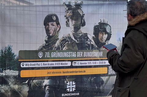 Wehrdienstleistende der Bundeswehr auf einem Banner zum 70-jährigen Bestehen der Truppe