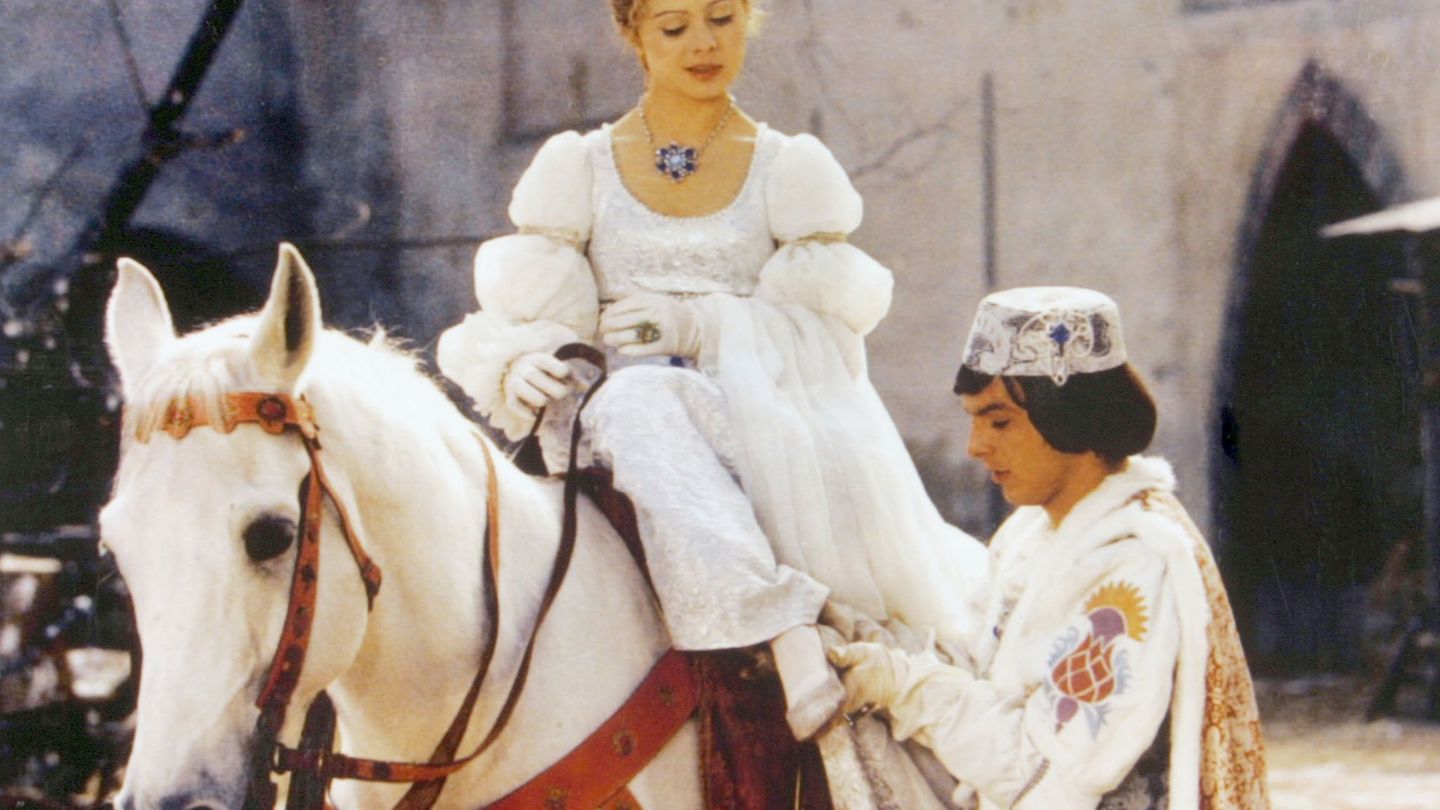 Der Prinz (Pavel Trávnícek) passt Aschenbrödel (Libuse Safránková) den verlorenen Schuh an. (Filmszene) Foto: Degeto/WDR/dpa