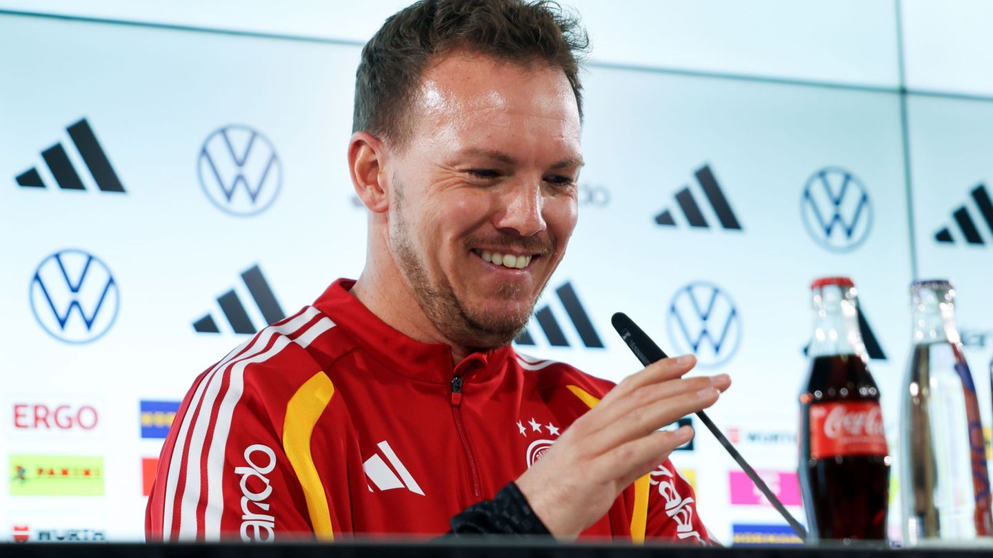 Julian Nagelsmann richtet das Mikrofon bei der Pressekonferenz. Foto: Christian Charisius/dpa