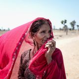 Eine Frau hält sich einen Schleier vors Gesicht