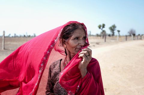 Eine Frau hält sich einen Schleier vors Gesicht