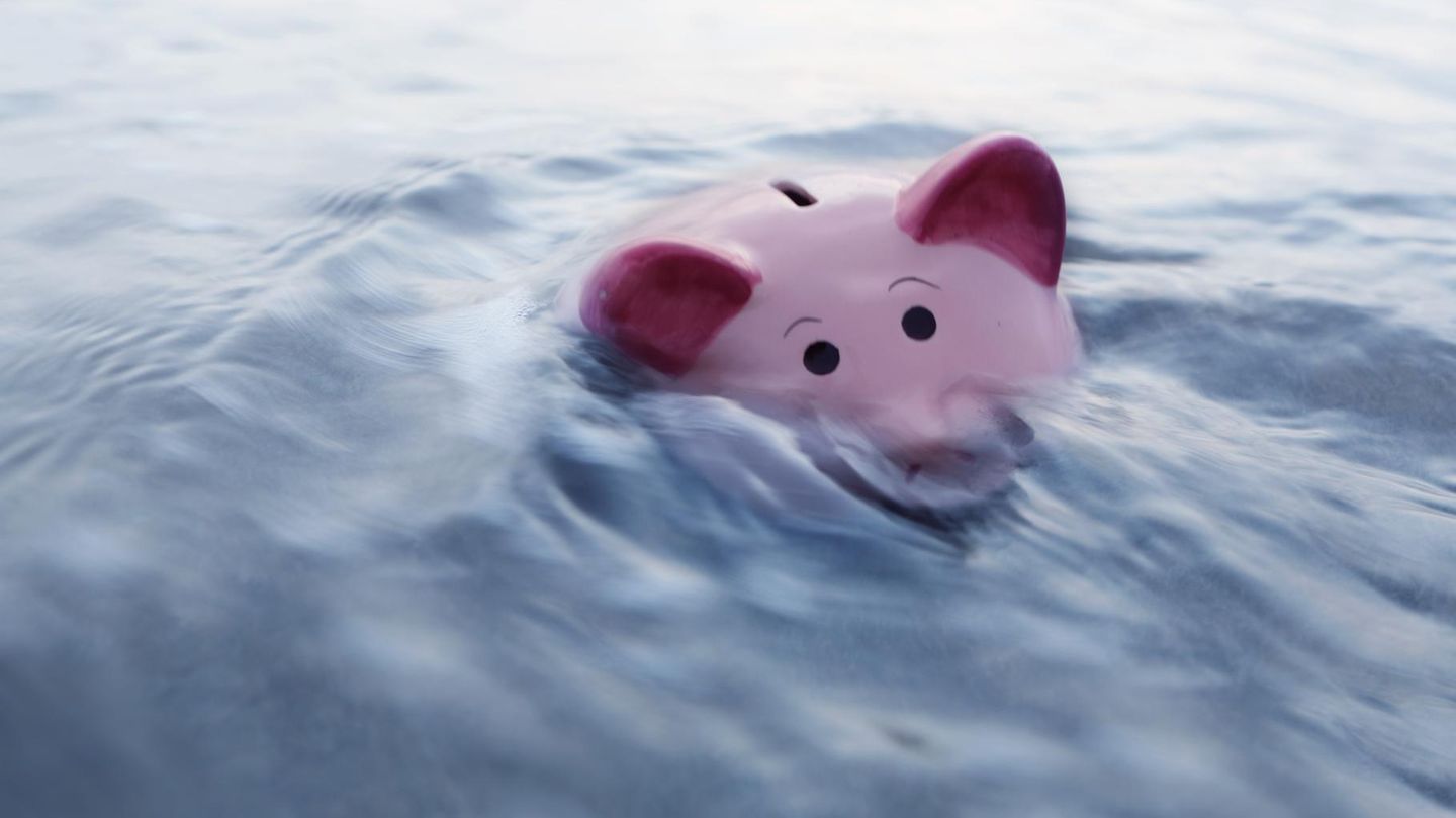 Ein Sparschwein geht im Wasser unter
