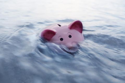 Ein Sparschwein geht im Wasser unter