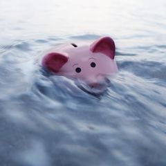 Ein Sparschwein geht im Wasser unter