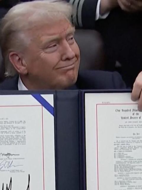 Donald Trump hält mit selbstbewussten Blickes das signierte Abkommen in der Hand.