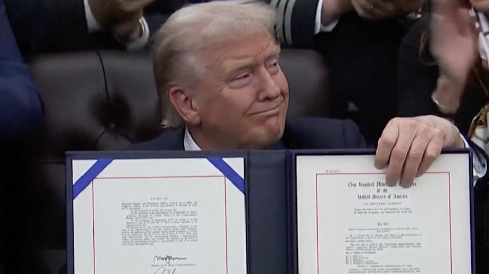 Donald Trump hält mit selbstbewussten Blickes das signierte Abkommen in der Hand.