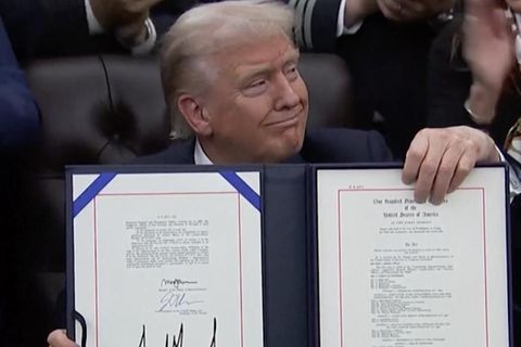 Donald Trump hält mit selbstbewussten Blickes das signierte Abkommen in der Hand.