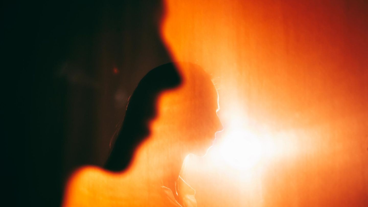 Eine Frau ist schemenhaft vor hellem Licht zu sehen. Denkt sie an Suizid?