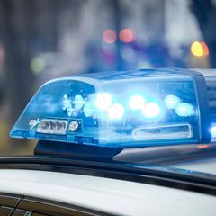 Ein Blaulicht der Polizei blinkt auf einem Autodach – Symbolbild für eine Großrazzia