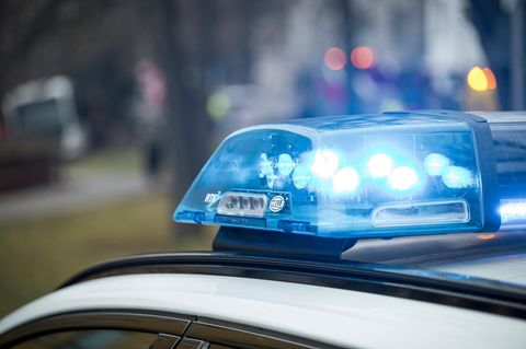 Ein Blaulicht der Polizei blinkt auf einem Autodach – Symbolbild für eine Großrazzia