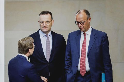 Jens Spahn und Friedrich Merz stehen im Bundestag