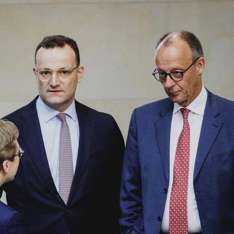 Jens Spahn und Friedrich Merz stehen im Bundestag