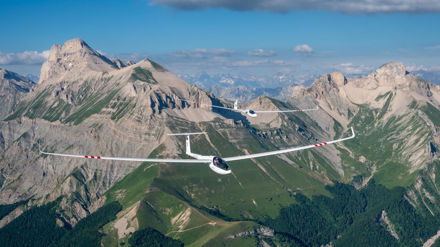 Zwei Segelflugzeuge im Formationsflug vor einem Alpenpanorama