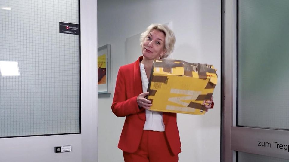 Eine Anwältin mit einem Paket in den Händen.