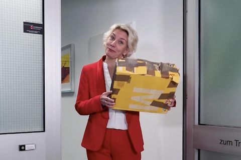 Eine Anwältin mit einem Paket in den Händen.